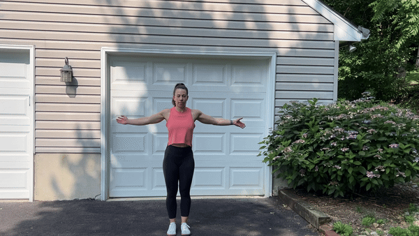 trainer doing arm circles outside in front of garage